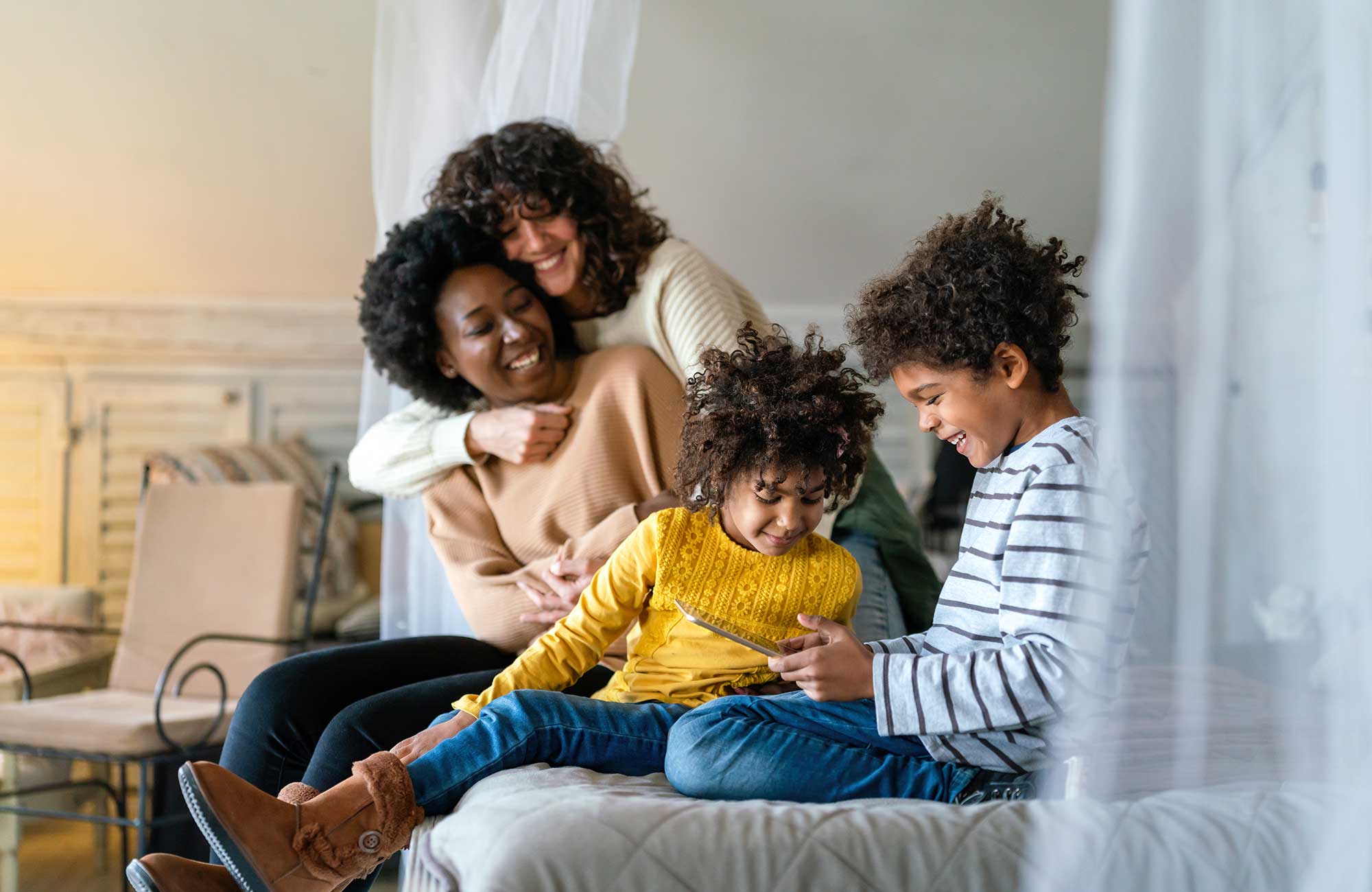 Two parents and two children spending time together on a sofa